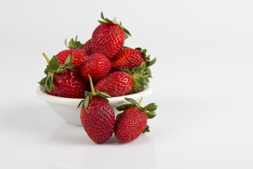 White bowl of fresh ripe red strawberries