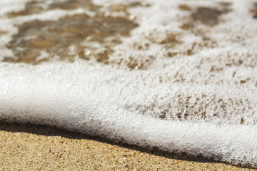 Beautiful colorful ocean wave breaking closing near sand beach