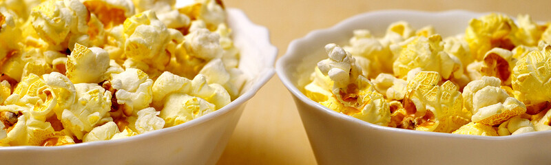big and small bowls of popcorn, shallow depth of field, suitable for header or banner