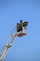 Two intrepid firefighters over the autoscale metal basket during