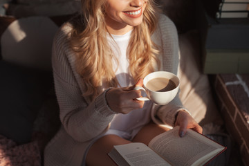 Woman with beverage and book