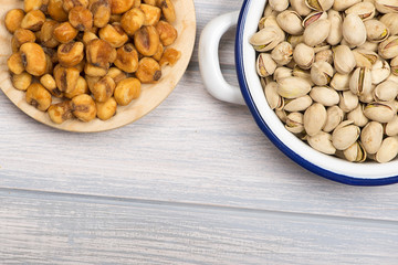 From above  pistachios and toasted corn on wooden background. Horizontal studio shot.