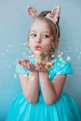 Cute little girl blowing magical dust.