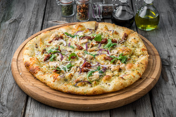 pizza with sun-dried tomatoes, prosciutto, arugula and parmesan cheese