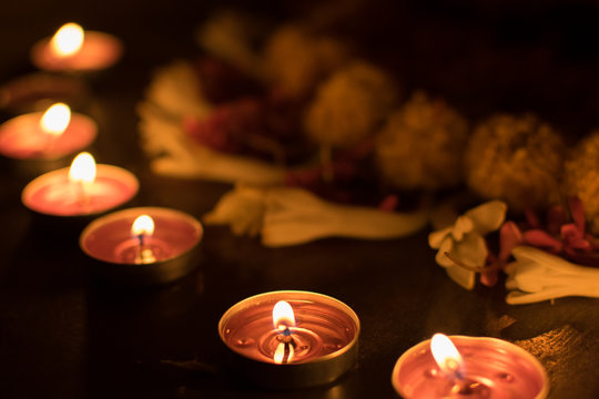 Low angle Rangoli flowers and candles or diyas, Diwali lights at night. Dark background stock image.
