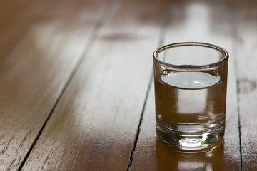 Drinking water in a glass is on a wooden table.