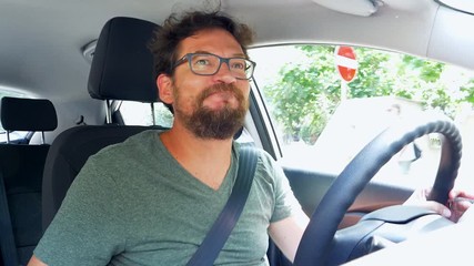 Handsome man looking for parking in city driving car