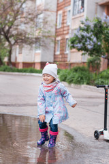 Little girl jumping in the puddle