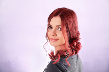 Beautiful young woman with dyed hair on color background