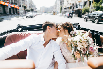 Just married couple in the blue retro car on their wedding