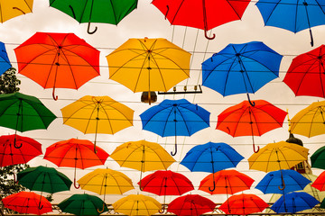 Fototapeta na wymiar Colorful hundreds of umbrellas floating above the street