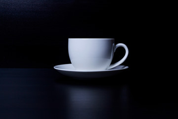 Hot coffee in the white cup and roasted on dark background
