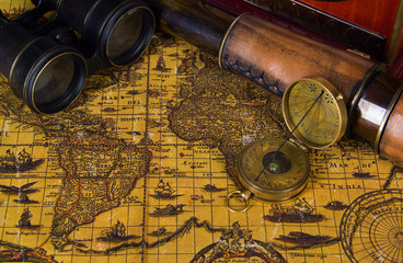 Ancient world map with a variety of accessoriesin vintage still.