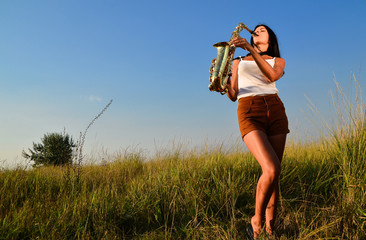 Woman playing saxophone in nature