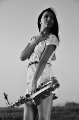 Beautiful girl holding a saxophone in his hands