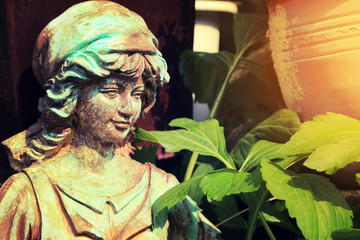 Obraz premium Metal sculpture of a girl decorated in garden with warm sunlight flare.