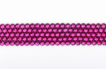 Precious sparkling rhinestones rose colors on a white background.