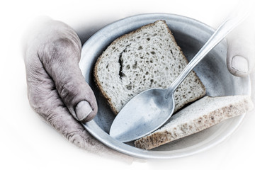 Men hands hold a metal plate and a spoon. On the plate lay two pieces of bread.
