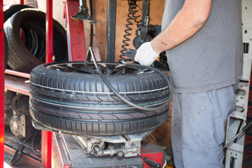 technician specialist changes car tire with his machine
