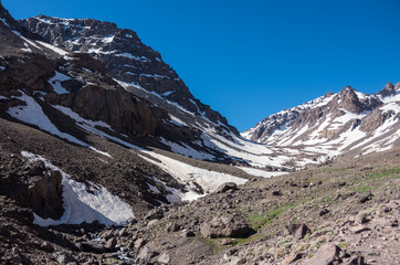 Fototapeta na wymiar Toubkal national park in springtime with mount, cover by snow and ice, valley near Refuge Toubkal, start point for hike to Jebel Toubkal, – highest peak of Atlas mountains and Morocco