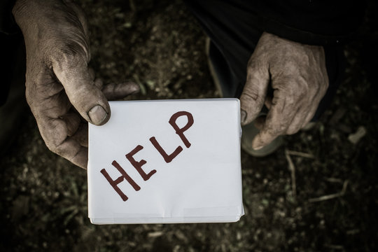 A man hands holding a box. The inscription on the box "help".
