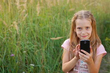 Good girl dials the number on the phone outdoors and going to call her girlfriend.