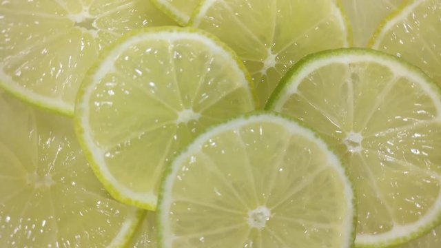Great background of juicy organic Lime slices rotating close up. Footage will work great for any videos dealing with summer, fun, alternative medicine, cosmetology and much more.