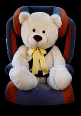  teddy bear fastened in the seat of a car