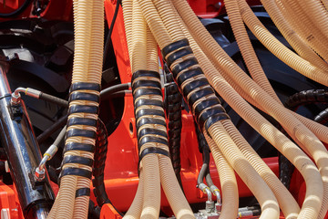 Fragment of a seeder with grain feeding hoses and hydraulic mechanisms