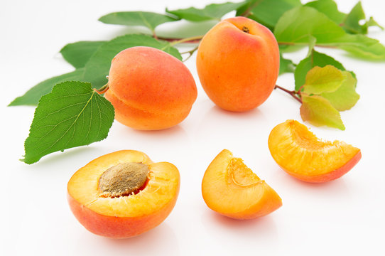 Ripe, juicy and appetizing apricot fruits with green leaves