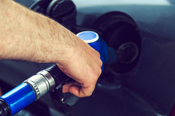 Close-up of a man's hand using a gasoline pump.