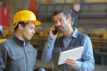 workers looking at digital tablet in warehouse