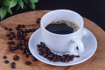 Hot coffee in the white cup and roasted on dark background
