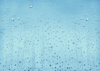 Texture drops of water on a transparent glass blue background