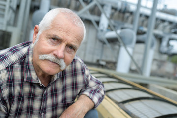 Portrait of senior man outdoors in industrial setting