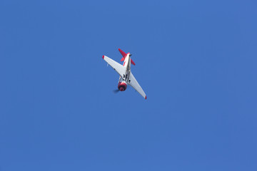 Fototapeta na wymiar Historical airplane doing manoeuvres in the sky. Veteran pilot with a veteran plane against a blue sky. Copy space.