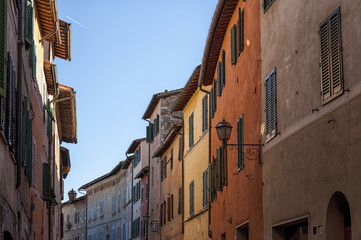 SAN QUIRICO D'ORCIA, ITALY - OCTOBER 30, 2016 - Charming narrow street in the town of San Quirico d'Orcia, province of Siena, Val d'Orcia, Tuscany, Italy