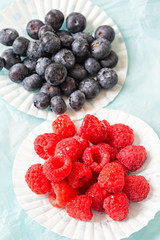 Raspberry and blueberry on blue background 
