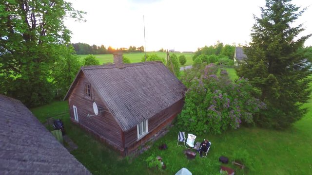 Traditional Estonian house golden hour aerial view 4K. Flying above the old Estonian building at sunset in background. Aerial footage landscape panorama.
