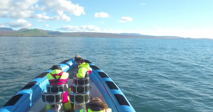 HUSAV&Iacute;K, ICELAND &ndash; SEPTEMBER 2016 : Video shot from speedboat on open ocean with mountains and ship in view on a bea