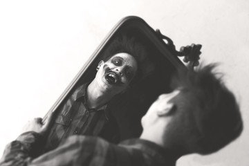 black and white crazy clown laughing in front of mirror