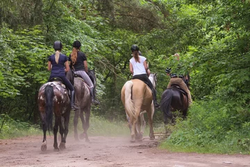 Tuinposter Group of friends riding horses in the forest © wb77