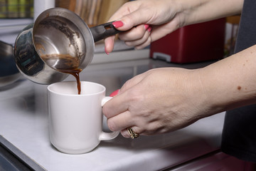 Fototapeta na wymiar woman's hand while cooking homemade coffee