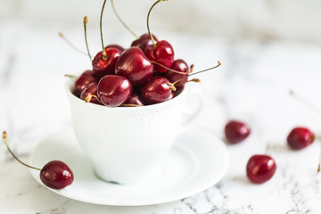 Ripe sweet cherry in a white mug