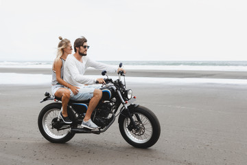 Fototapeta na wymiar Young beautiful couple riding motorcycle