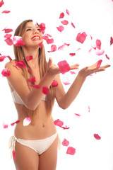 Obraz na płótnie Canvas Beautiful young woman portrait with rose petals