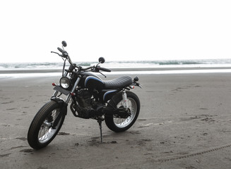 Fototapeta na wymiar Motorcycle at sunset on a sandy beach