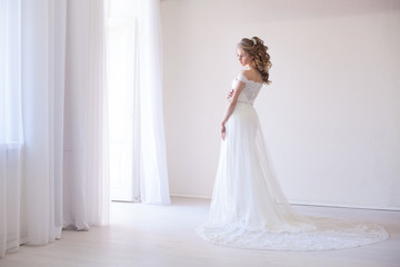 Fototapeta na wymiar bride in wedding dress in a white room