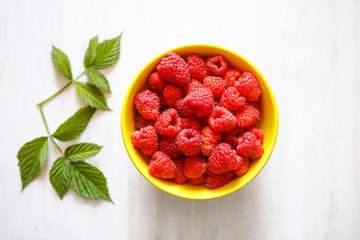 Sweet raspberries in bowl on table. Close up, top view, high res