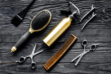 Hairdressing tools on grey wooden background top view